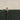 Close-up of a man in a cap at the top of the ladder, trimming the very top of the hedge. Verdant Vertigo