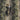 Close-up of a nun lying down, drinking wine from a bottle next to a basket of grapes. Vineyard Confession