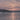 Close-up of a sunset over a frozen lake with a wooded shore and snow. Frostlit Farewell