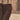 Close-up of trousers with braces against a stone-paved street and a wall. Terracotta Tango