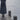 Close-up of a woman's coat and shoes on a jetty beside wooden bollards. Three Quiet Oaths
